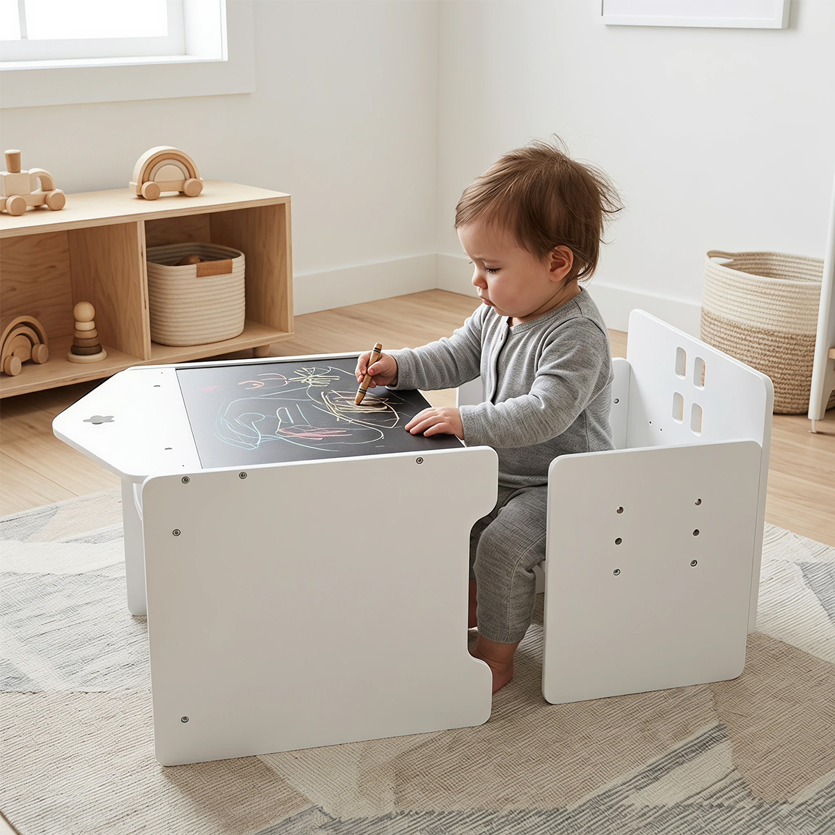 Toddler drawing on white Montessori table and chair set with chalkboard surface