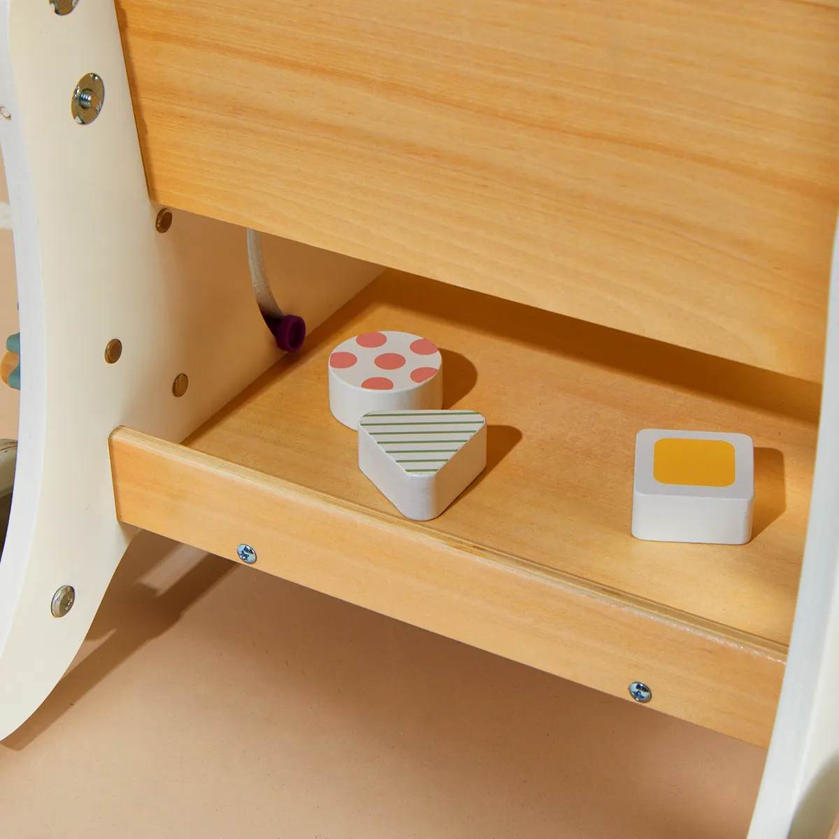 Bottom storage tray of wooden doll stroller storing shape sorter blocks